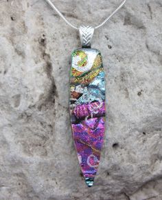 "This is a beautiful One of a Kind pendant created with gorgeous of pink and yellow dichroic glass, and silver dichroic accents.It has gorgeous layers of color and texture.This pendant measures approximately 2.3\"x.7\"(5.9cmx1.9cm) at the widest points and is securely attached with a lovely silver plated bail.The matching adjustable16\"-18\"snake chain is included. If you would prefer a black cord instead,just let me know. Each purchase arrives in a pretty organza pouch. All of my jewellery is c Emerald Green Necklace, Dichroic Jewelry, Lily Necklace, Dichroic Glass Jewelry, Fused Glass Necklace, Dichroic Pendant, Yellow Necklace, Dichroic Glass Pendant, Green Pendants