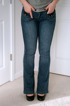 a woman standing in front of a door with her hands on her hips