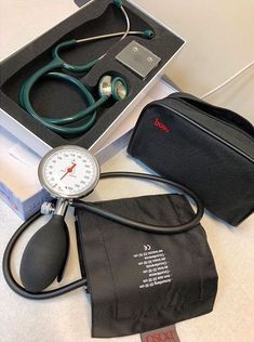 a medical kit with a stethoscope in it and a black bag next to it