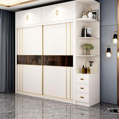 a white closet with gold trimmings in a living room area next to a window