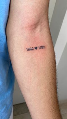 a man with a tattoo on his arm that reads 1932 and has hearts in it