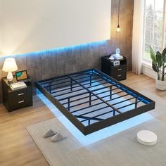 a bed frame with blue lights on it in a room next to two nightstands