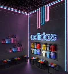 the adidas store is lit up in purple and blue colors with neon letters on the wall