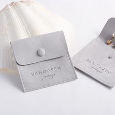 a pair of earrings sitting on top of a piece of paper next to a seashell