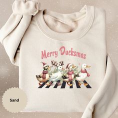 a white sweater with ducks on it and the words merry ducksmass written in pink