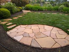 a circular stone path in the middle of a garden