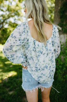 This floral blouse is so pretty and feminine! Features a square neckline and ruffle detailing. Dress it up for work or down with denim shorts and some flip flops. lined bodice elastic cuffs & neckline tie closure & keyhole center care instructions: hand wash cold water, hang dry 100% polyester true to size, relaxed fit Paige is 5'6" wearing a small Spring Flowy Blouse With Smocked Back, Feminine Spring Blouse With Smocked Back, Spring Smocked Back Square Neck Blouse, Spring Square Neck Blouse With Smocked Back, Spring Blouse With Smocked Back For Day Out, Spring Brunch Blouse With Smocked Back, Spring Blouse With Smocked Back For Brunch, Summer Ruffles Blouse For Garden Party, Feminine Square Neck Blouse For Spring