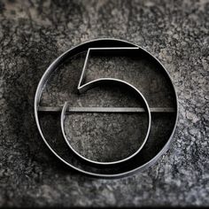 the number five logo is displayed on a granite surface in black and grey tones,