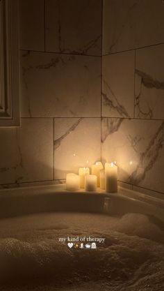 candles sit in the middle of a bathtub filled with water