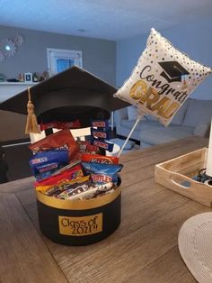 a graduation cap sits on top of a table with candy and confetti in it