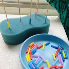 a plate with toothpicks stuck in it on a table next to a bowl