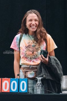 a woman smiles while holding a cell phone