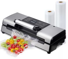 a machine that is sitting next to some fruit and vegetables in plastic wrappers on a white surface