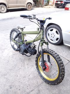 a green and yellow bike parked next to a car