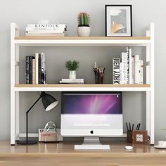 a computer monitor sitting on top of a wooden desk