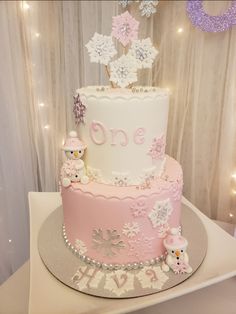 a pink and white cake sitting on top of a table