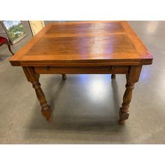 a wooden table sitting on top of a metal floor