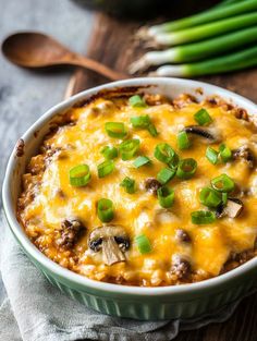 a casserole dish with cheese, mushrooms and green onions