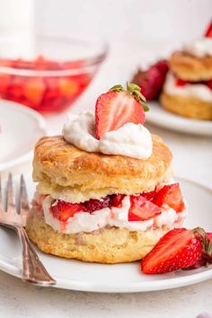 strawberry shortcakes stacked on top of each other with whipped cream and strawberries