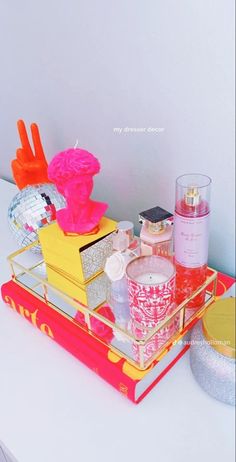 an assortment of beauty products sitting on a tray next to a candle and other items