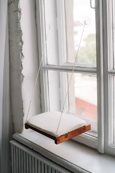 a white pillow sitting on top of a window sill next to a radiator