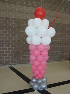 there is a balloon tower made out of balloons in the middle of a room with black and white stripes