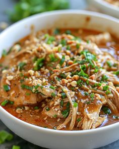 a close up of a bowl of food with meat and veggies in it