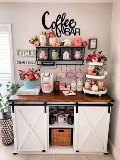 a coffee bar is decorated with pink and white flowers