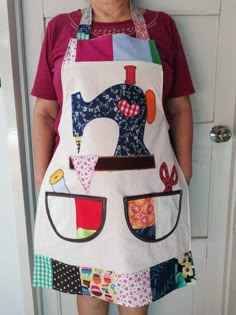 a woman standing in front of a white door wearing an apron with patches on it