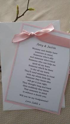 a wedding card with a pink ribbon and poem on the front, sitting on a table