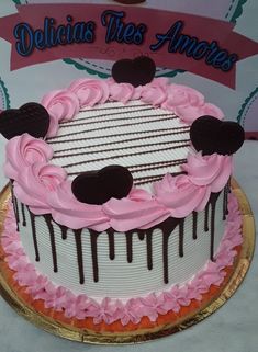 a cake decorated with pink icing and chocolate hearts