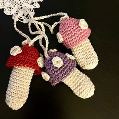 three crocheted teddy bears hanging from a string on top of a black table