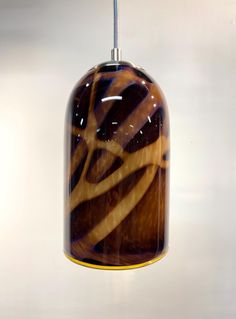 a brown and yellow glass light hanging from a ceiling