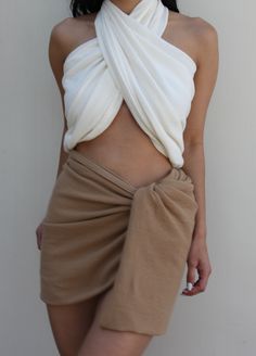 The Ellie Sarong is our most versatile piece yet and was inspired by our love of waffled cotton, which we wanted to make available in as many styles as possible. We envision the Ellie as a year-round accessory that can be tied as a halter or bandeau top, easy sarong skirt or cover-up, or draped as a classic shawl or scarf. Ideal for a variety of settings - from everyday summer comfort to luxurious resort wear. Pair with coordinating Bobbie Wrap Skirt, Chloe Shorts, or Patricia Pants for a sophis White Cotton Tie-back Halter Top, Scarf Skirt, Honeycomb Texture, Luxurious Resort, Sarong Skirt, Scarf Top, Cotton Scarf, Bandeau Top, Sarong