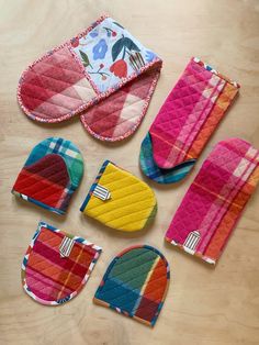 several oven mitts and pot holders on a table