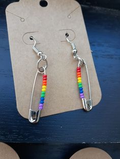 two pairs of earrings with rainbow beads hanging from them