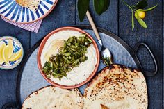 two pita breads on a plate next to a bowl of hummus