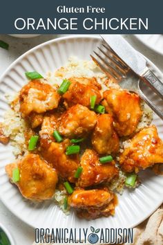 orange chicken with rice and green onions on a white plate