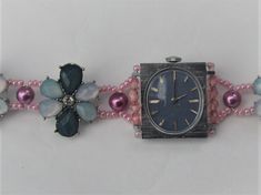 A pre-owned ladies wind-up watch with the strap replaced by a turquoise and pink fashion jewellery bracelet, length approx. 195mm (7.75 ins). The watch is pre-owned and has been revitalised by the addition of a handmade jewelled bracelet. The watch, which has a wind-up mechanism, is contained in a rectangular silver coloured metal casing (approx. 25mm x 22mm). The oval watch face is grey with a blueish tinge, having silver coloured pointers and hour markings. The main links in the bracelet repre Pink Bracelet Strap Jewelry For Formal Occasions, Pink Bracelet Style Jewelry For Formal Occasions, Formal Pink Jewelry With Bracelet Strap, Pink Watches With Bracelet Strap For Gift, Pink Watches With Bracelet Strap As Gift, Oval Watch, Turquoise And Pink, Womens Bangles, Bracelet Watches Women