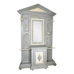 an old fashioned gray cabinet with mirror on it's front and side doors open