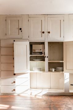 an empty kitchen with white cabinets and drawers