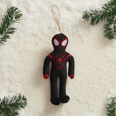 a spider man ornament hanging from a christmas tree