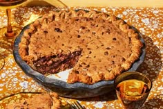 a pie sitting on top of a table next to two glasses