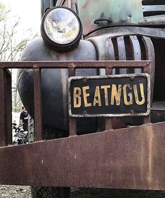 an old beat up truck is parked on the grass