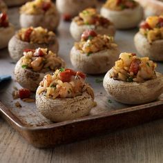 several stuffed mushrooms with various toppings on a tray