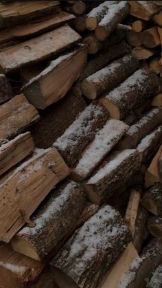 logs stacked on top of each other covered in snow