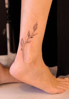 a woman's foot with a small flower tattoo on her left side calfocks