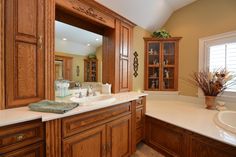 a large bathroom with wooden cabinets and white counter tops