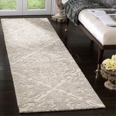 a large white rug on top of a wooden floor