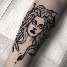 a woman's face with long hair and snake skin on her arm, done in black ink